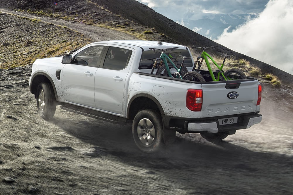 Ford Ranger ladattava hybridi ajamassa ylämäkeen kaksi polkupyörää kuormalavalla.