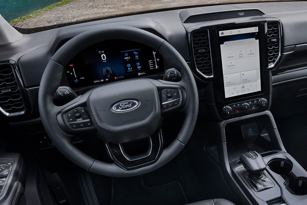 Sisäkuva Ford Ranger Wildtrakin ohjauspyörästä ja keskikonsolissa olevasta SYNC™ 4 -järjestelmän 12" kosketusnäytöstä.