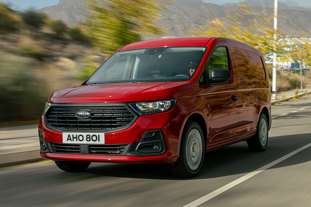Ford Transit Connect ajamassa tiellä, näkyvissä etusäleikkö ja automaattiset ajovalot.