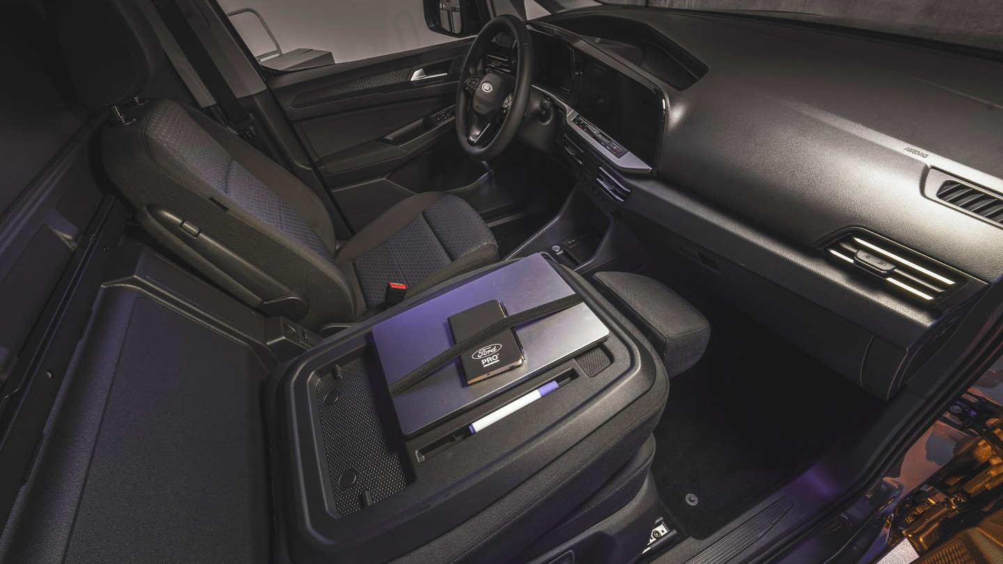 Kannettava tietokone ja Ford Pro -muistivihko täysin uuden Ford Transit Connectin työtasolla.