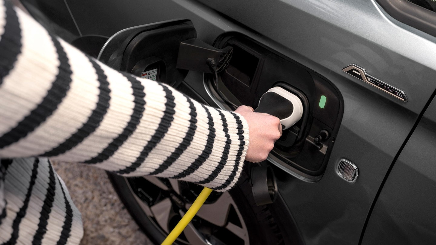 Latauskaapeli kytkettynä Boundless Blue -värisen Ford Tourneo Connectin porttiin. 