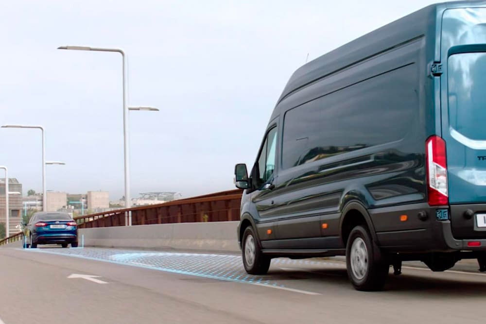 Sininen Ford Transit Van ja siniset viivat tiellä kuvaamassa edistyneiden kuljettajaa avustavien järjestelmien käyttöä.