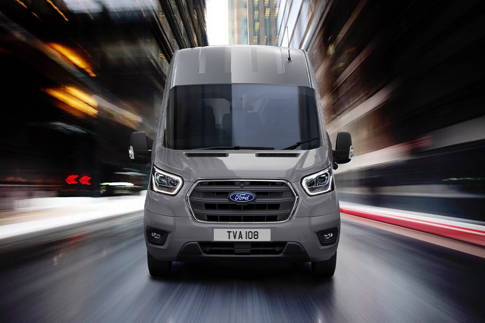 Ford Transit Van edestä kuvattuna ajamassa kaupungilla.