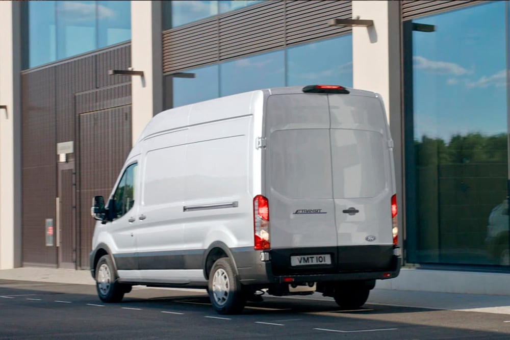 Kaupungin kadulle pysäköity hopeanvärinen Ford Transit Van takaa kuvattuna. 