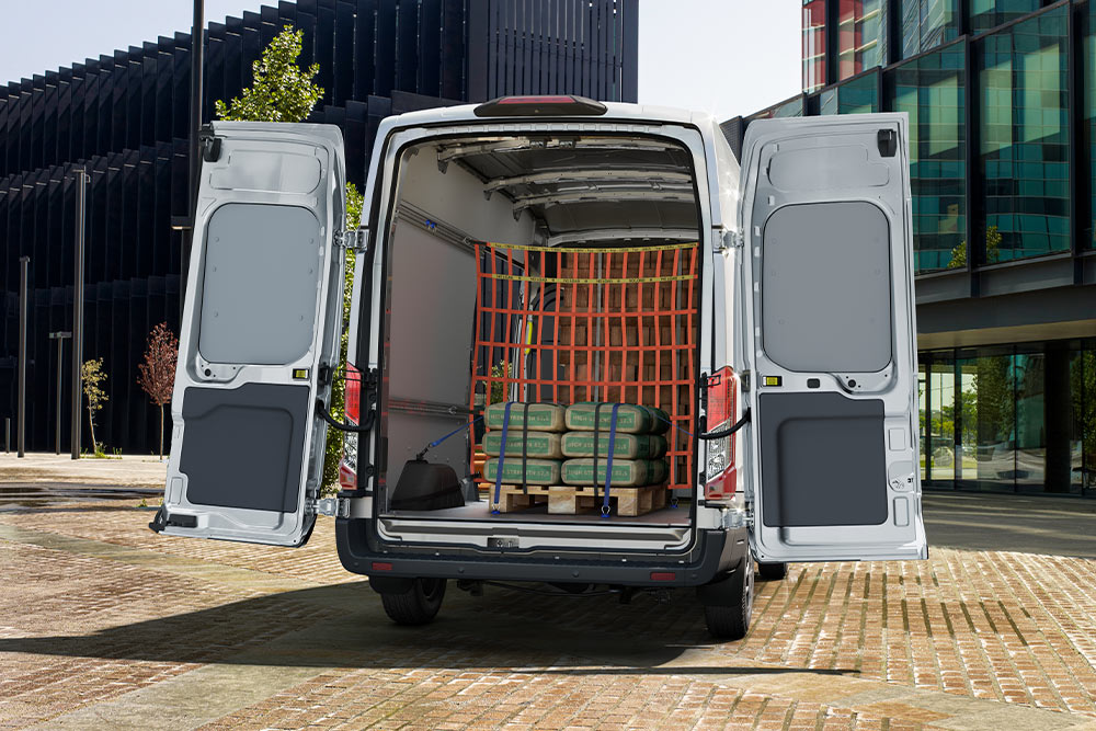 Ford Transit Jatko-ohjaamopakettiauto, jossa on takaovet auki ja kuorma sisällä.