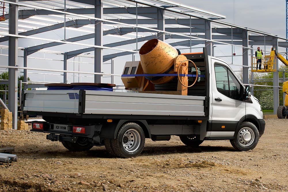 Ford Transit Chassis Cab pysäköitynä rakennustyömaalle; kuormalavalla betonisekoitin. 