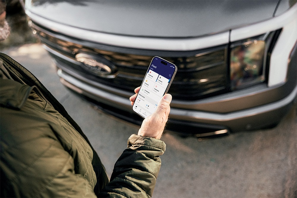 Mies katsoo älypuhelintaan Ford Rangerin edessä