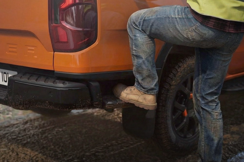 Työntekijä astumassa Ford Ranger Wildtrak -mallin takapuskuriin integroidulle askelmalle.