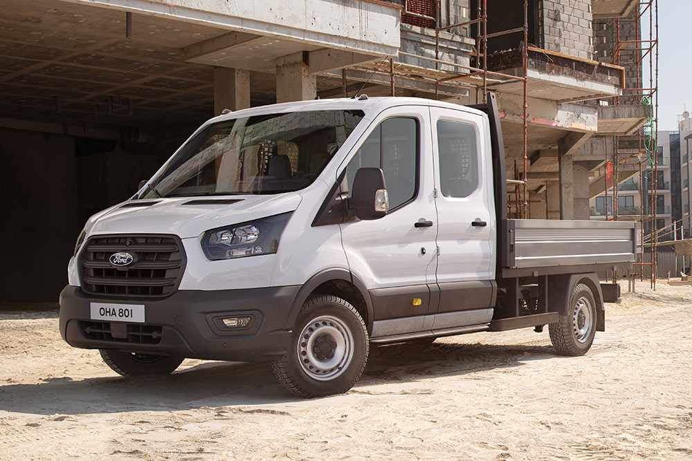  Valkoinen Ford Transit Custom -alustamalli lavalla on pysäköity rakennustyömaalle.