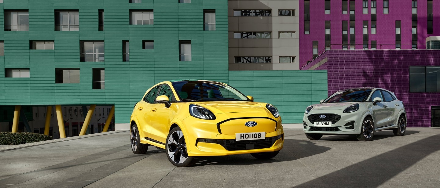 Keltainen Ford Puma Gen-E® -sähköauto pysäköitynä harmaan bensiinikäyttöisen EcoBoost® Ford Puman® viereen.