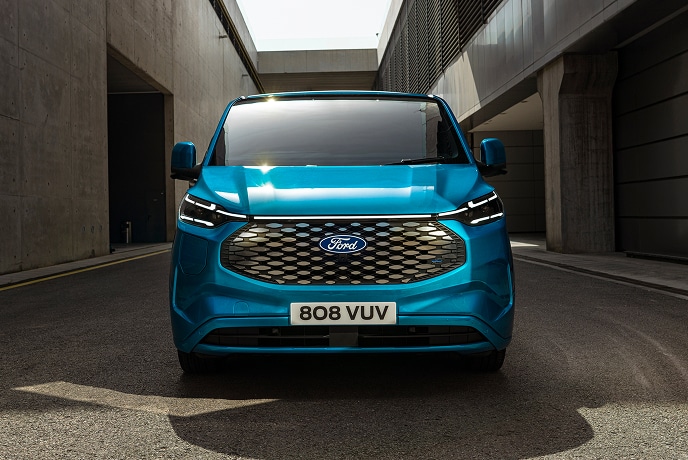 Sininen sähköinen Ford E-Transit Custom -pakettiauto edestä päin.