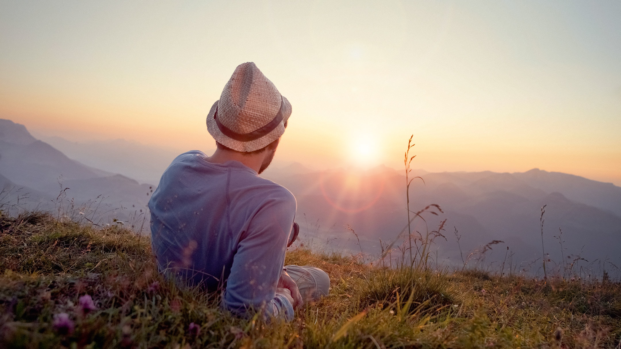Mies ihailee rauhallisena auringonlaskua