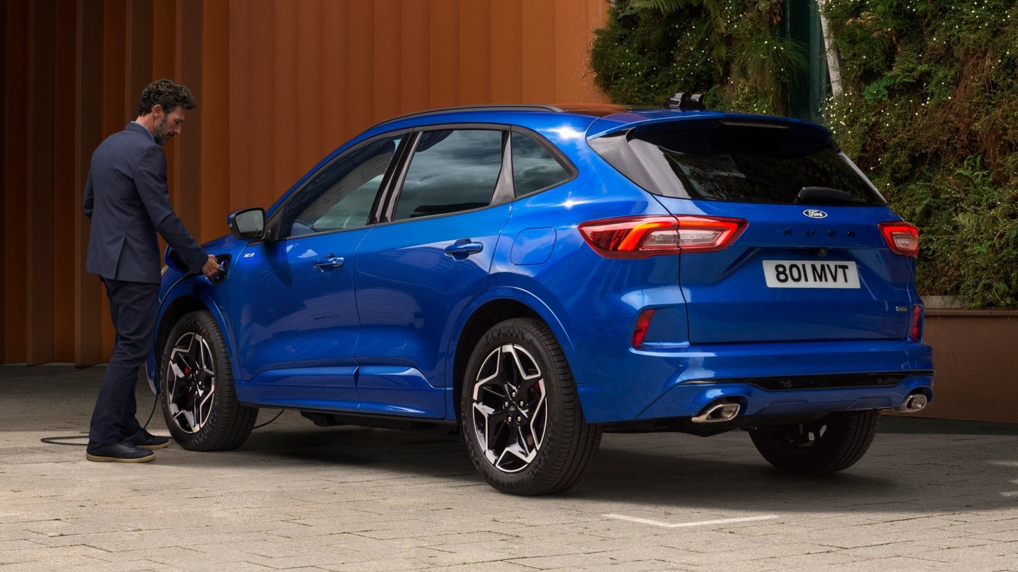 Sininen upouusi Ford Kuga ladattava hybridi kotona